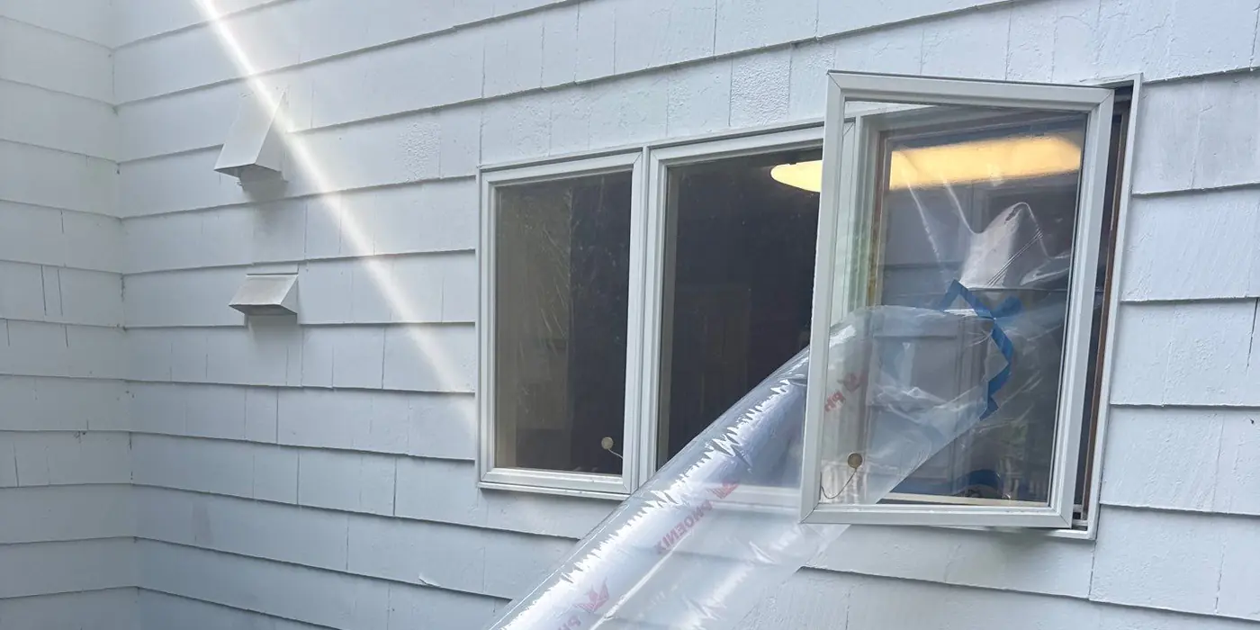 Negative-air machine exhausting through a sealed window during abatement