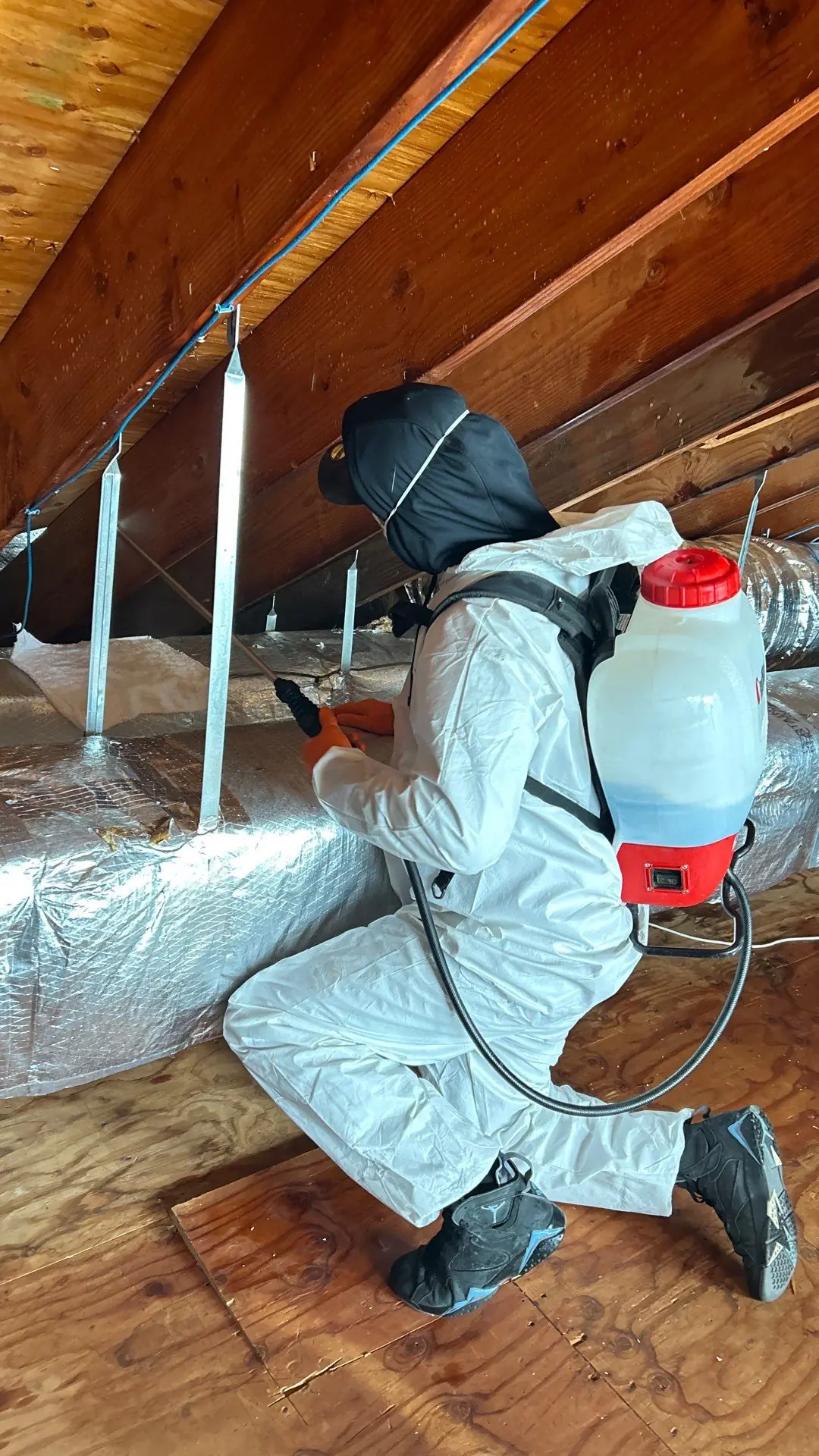Coating being sprayed onto attic rafters and roof decking