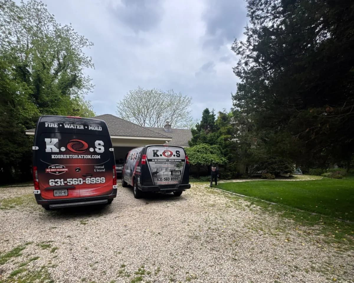 K.O.S. vans in the driveway of a Westhampton home for an emergency water loss