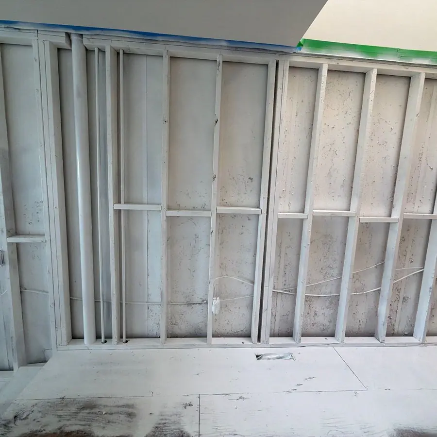 Fully encapsulated wall framing, white and uniform, ready for drywall