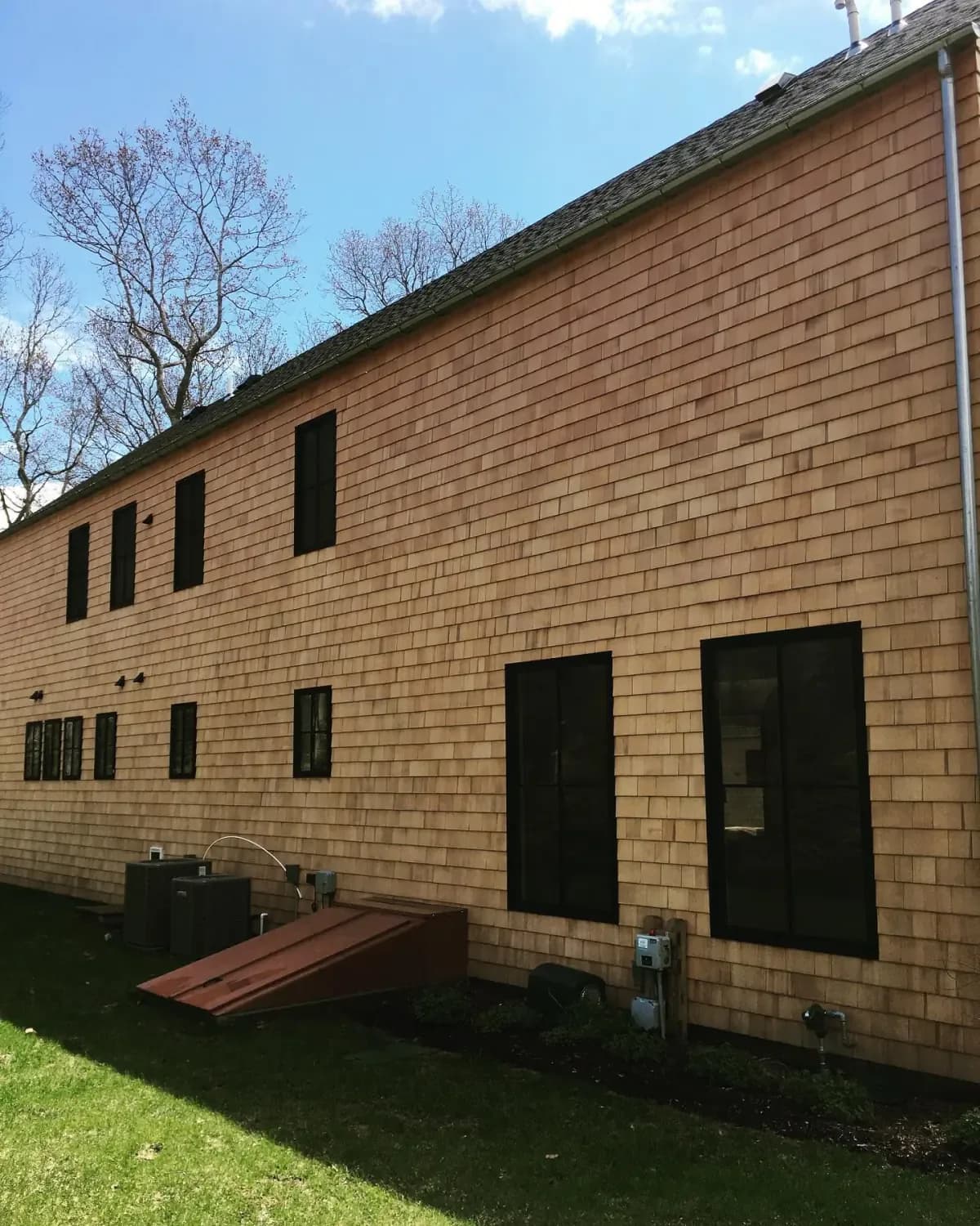 The same cedar shake wall restored to warm brown after soft washing