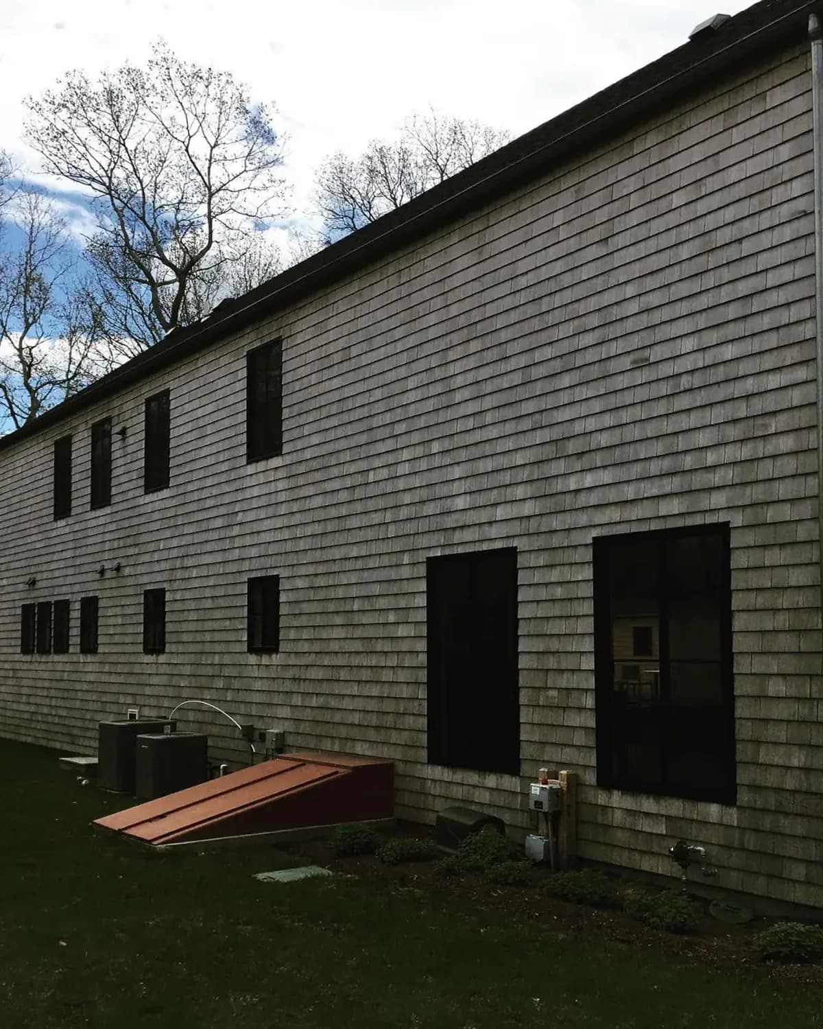 Long cedar shake wall weathered gray before soft washing