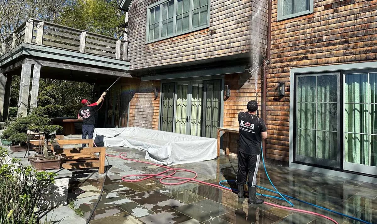 K.O.S. crew soft-washing the cedar shake siding of a Long Island home