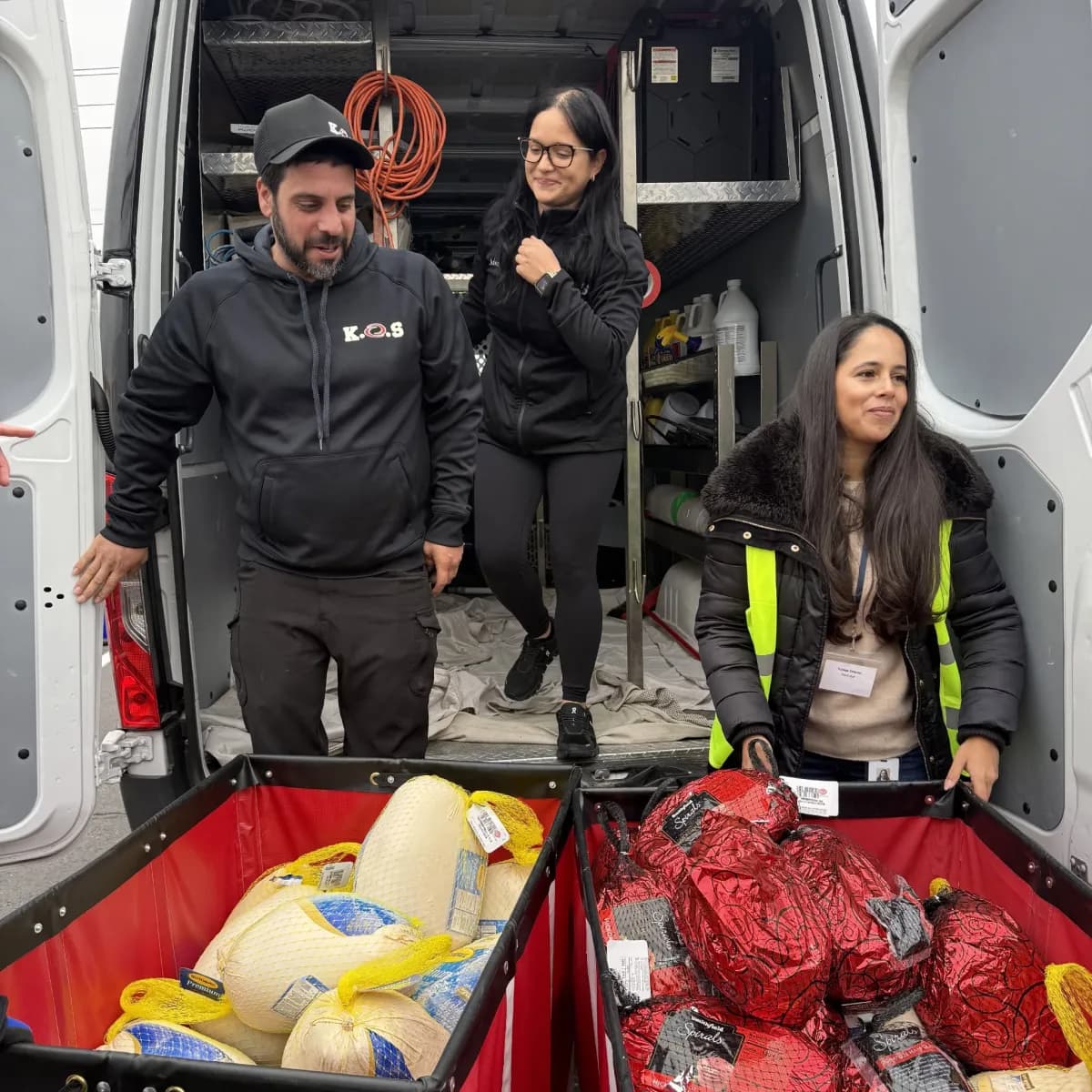 K.O.S. Restoration team and Island Harvest volunteers filling bins with turkeys and hams