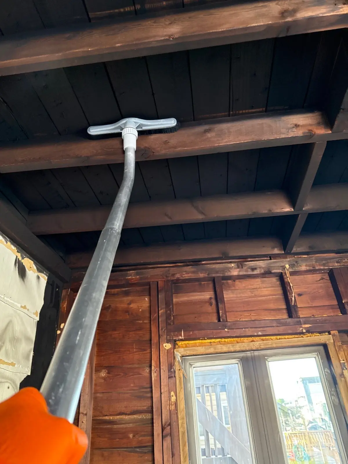 HEPA vacuum wand working soot out from between the ceiling joists