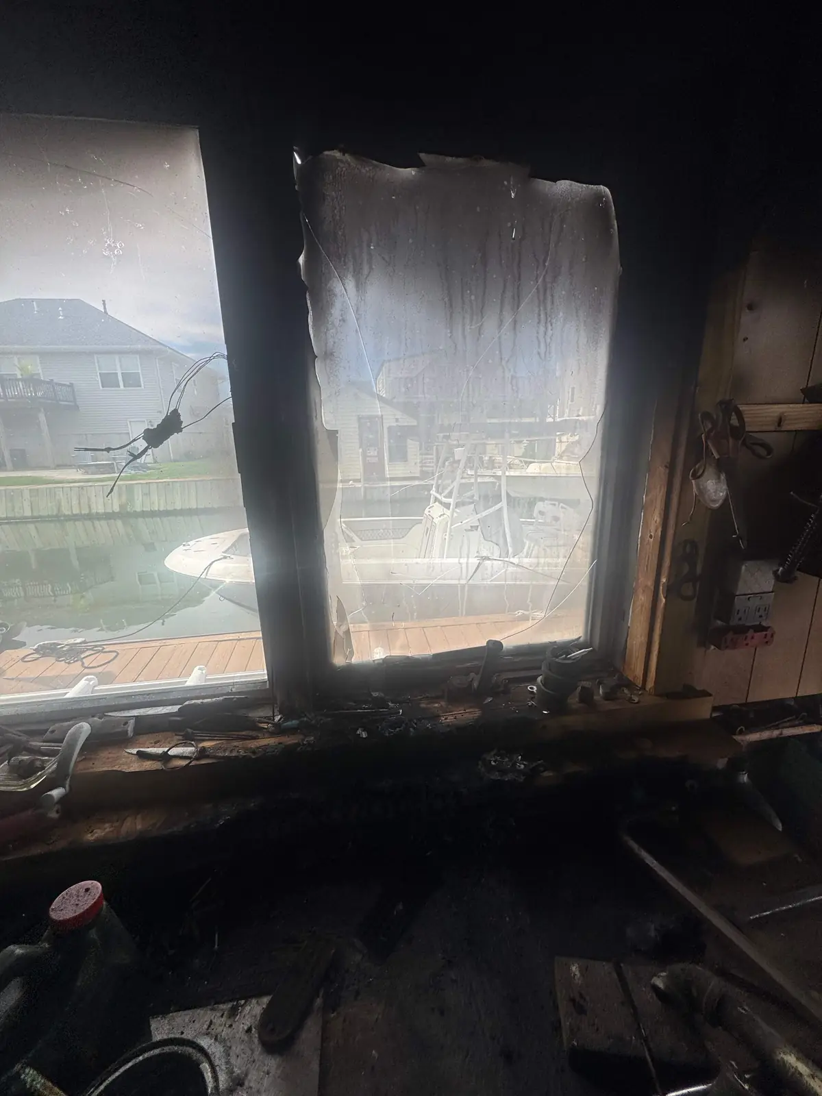 Charred window frame and soot-blackened wall after a house fire