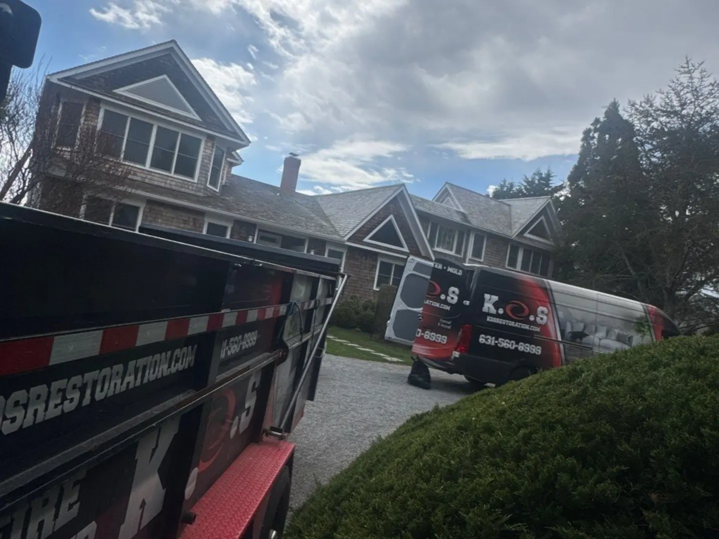 K.O.S. Restoration trucks on site at a shingle-style home in the Hamptons