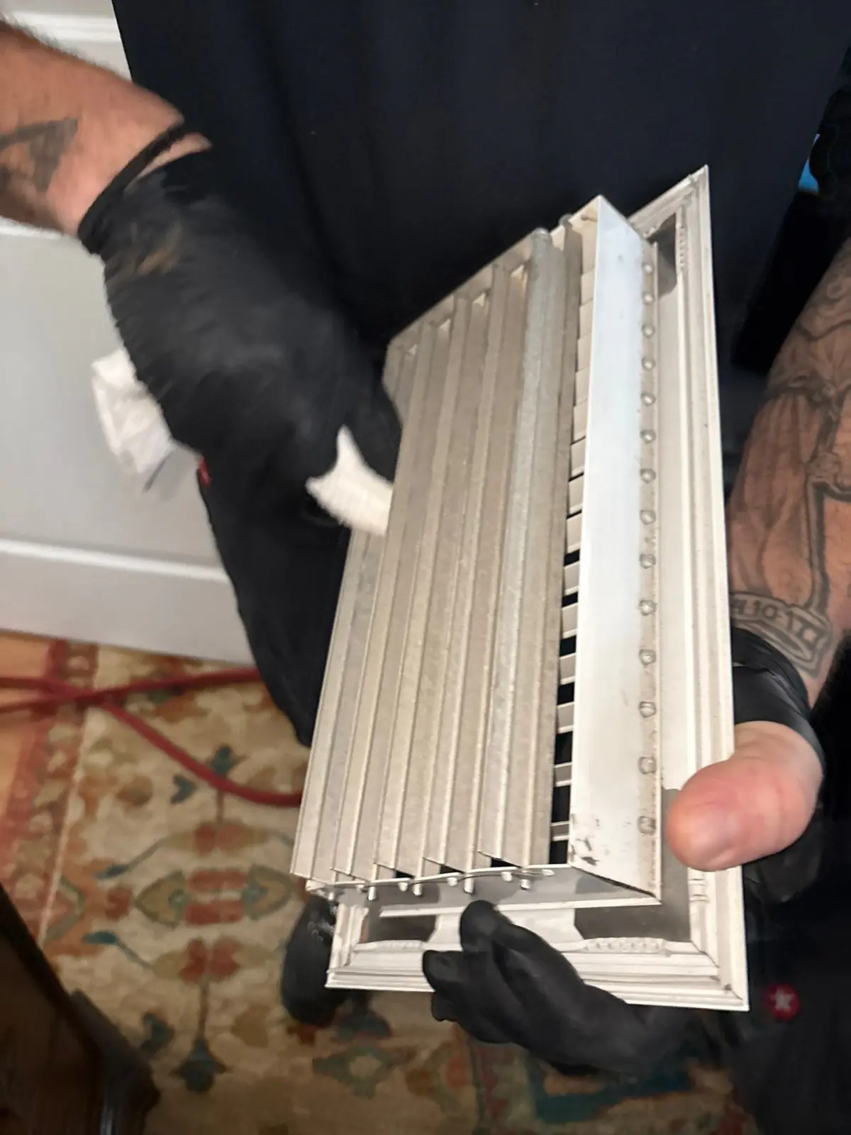 Technician hand-cleaning a vent cover during air duct cleaning in East Patchogue