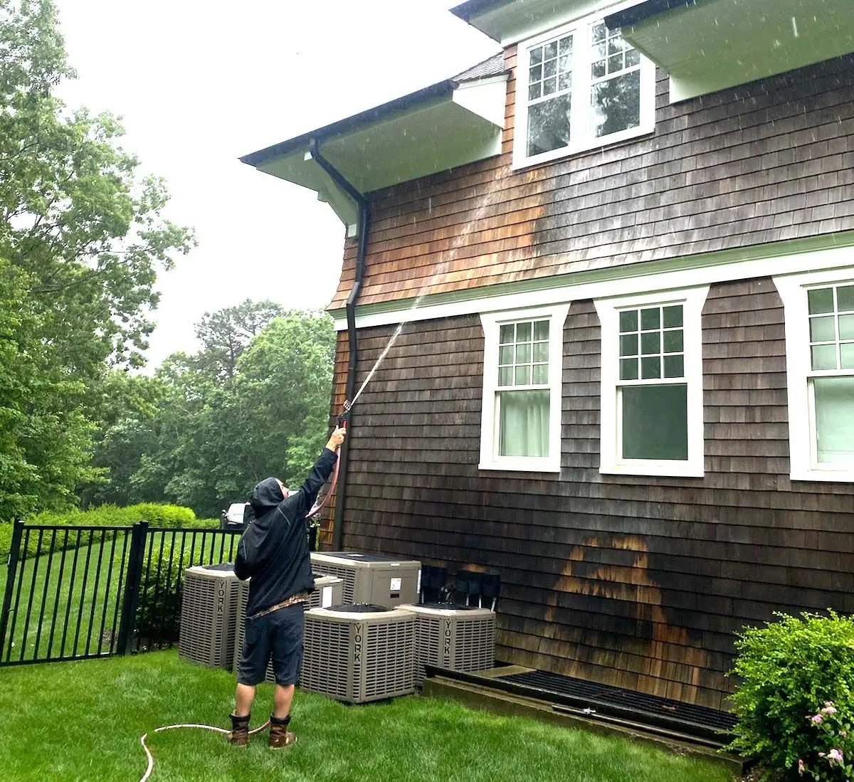 K.O.S. technician soft-washing the shingle siding of a Long Island home