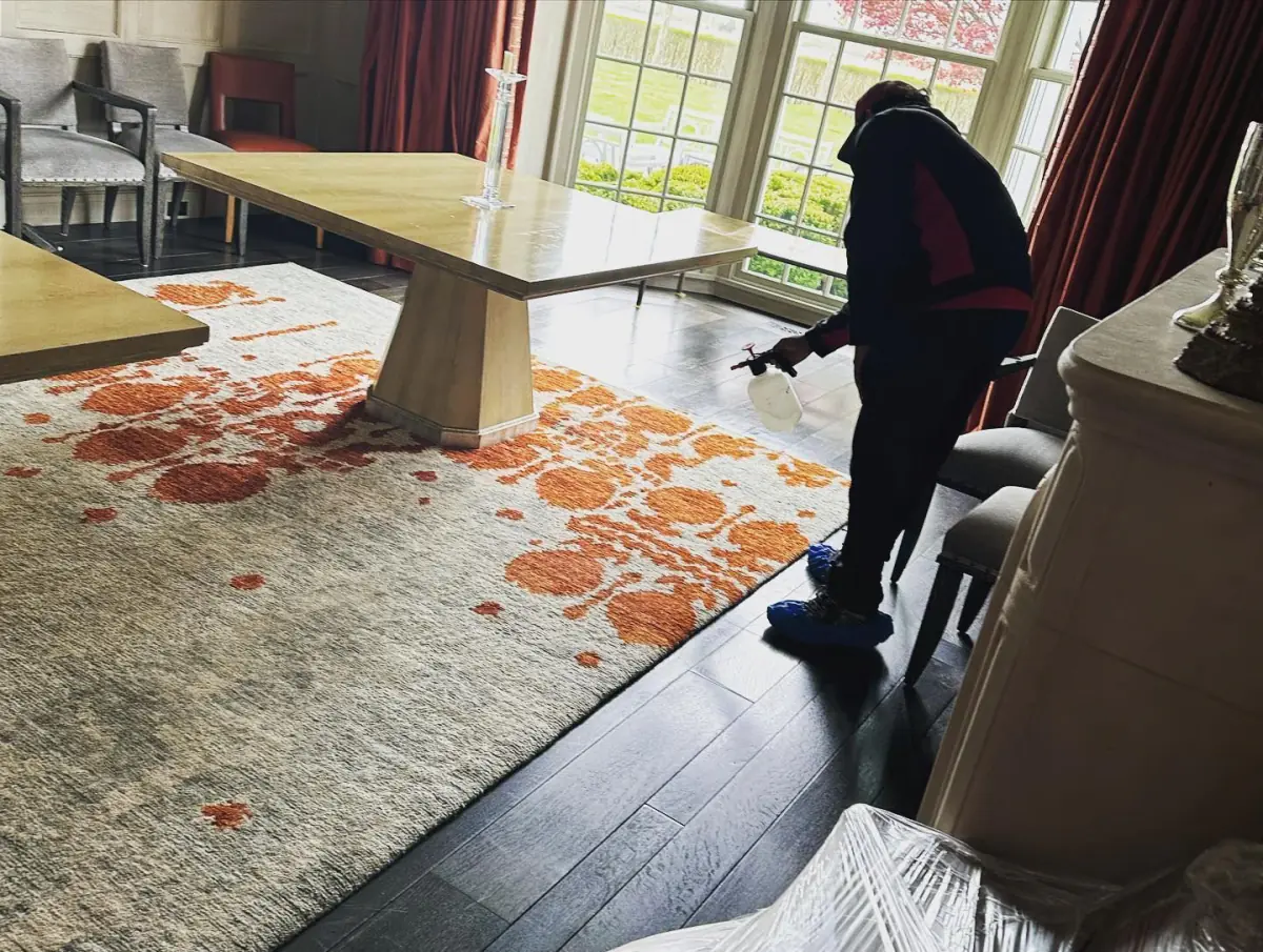 K.O.S. technician cleaning an area rug in a Long Island dining room