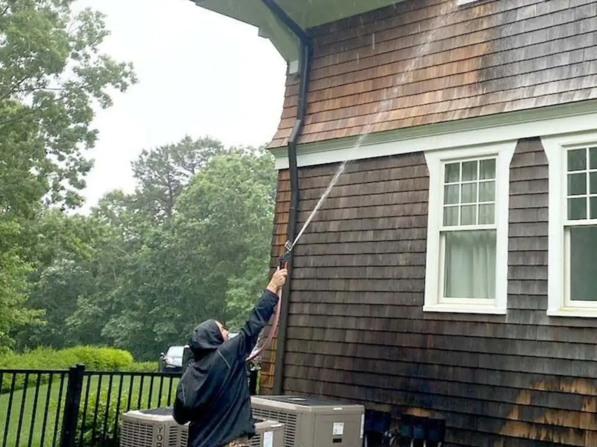 K.O.S. technician soft-washing the shingle siding of a Long Island home
