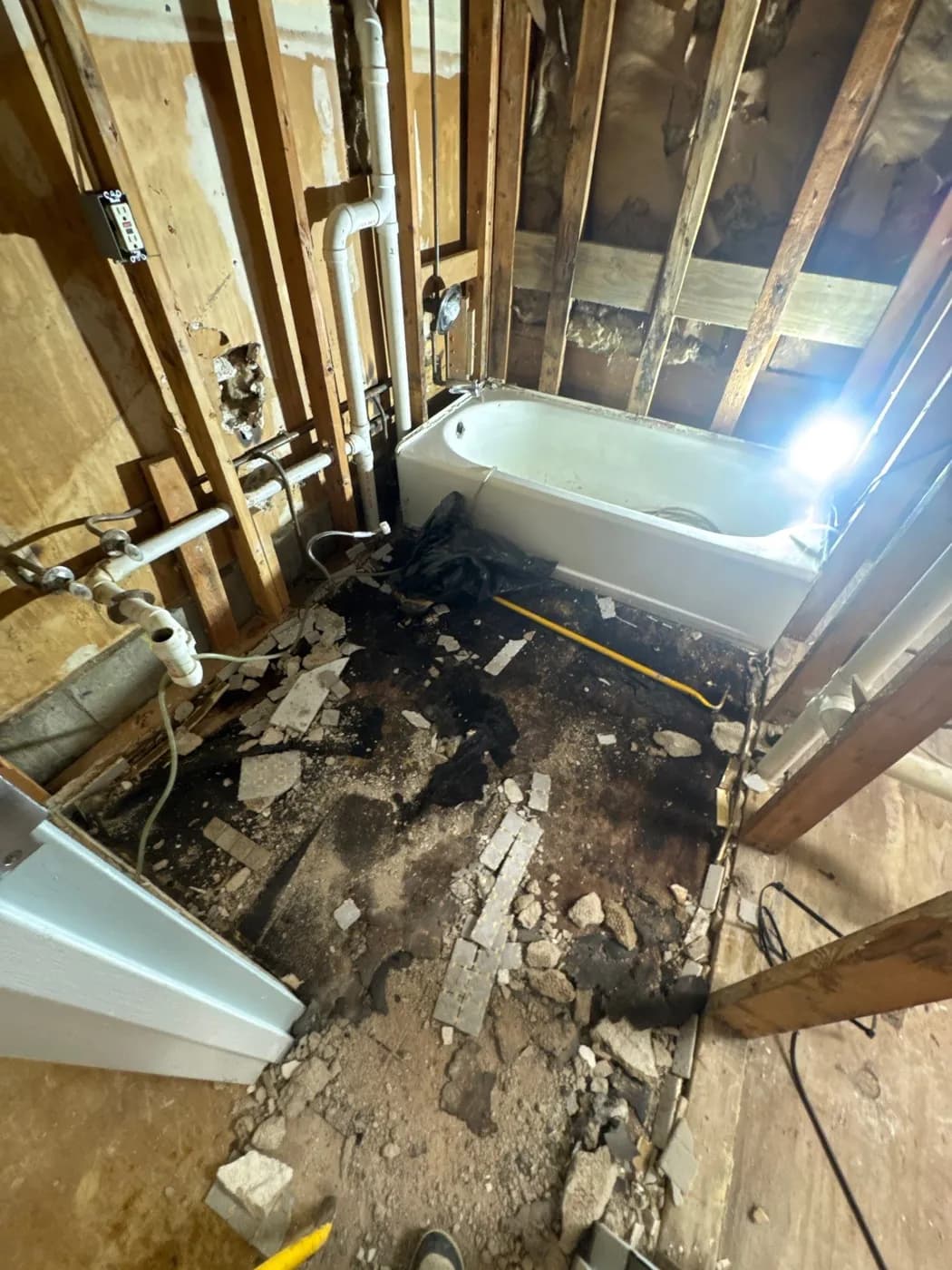 Bathroom floor and tub area after demolition during water damage restoration in Greenlawn NY