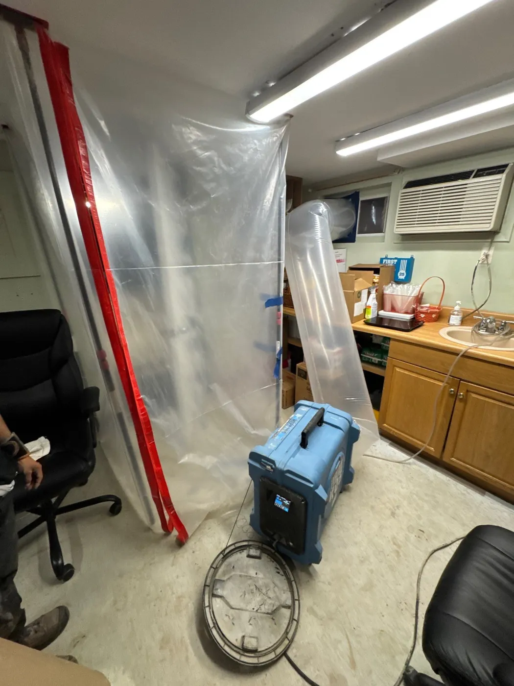 Plastic containment barrier protecting the basement office during mold remediation in Greenlawn NY