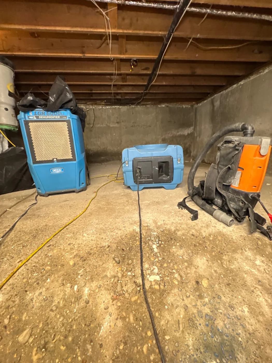 Commercial dehumidifiers and HEPA vacuum in a Greenlawn NY basement during remediation
