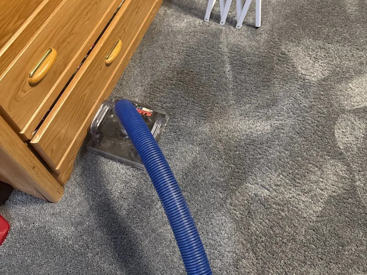 Extracting water from the carpet along the dresser