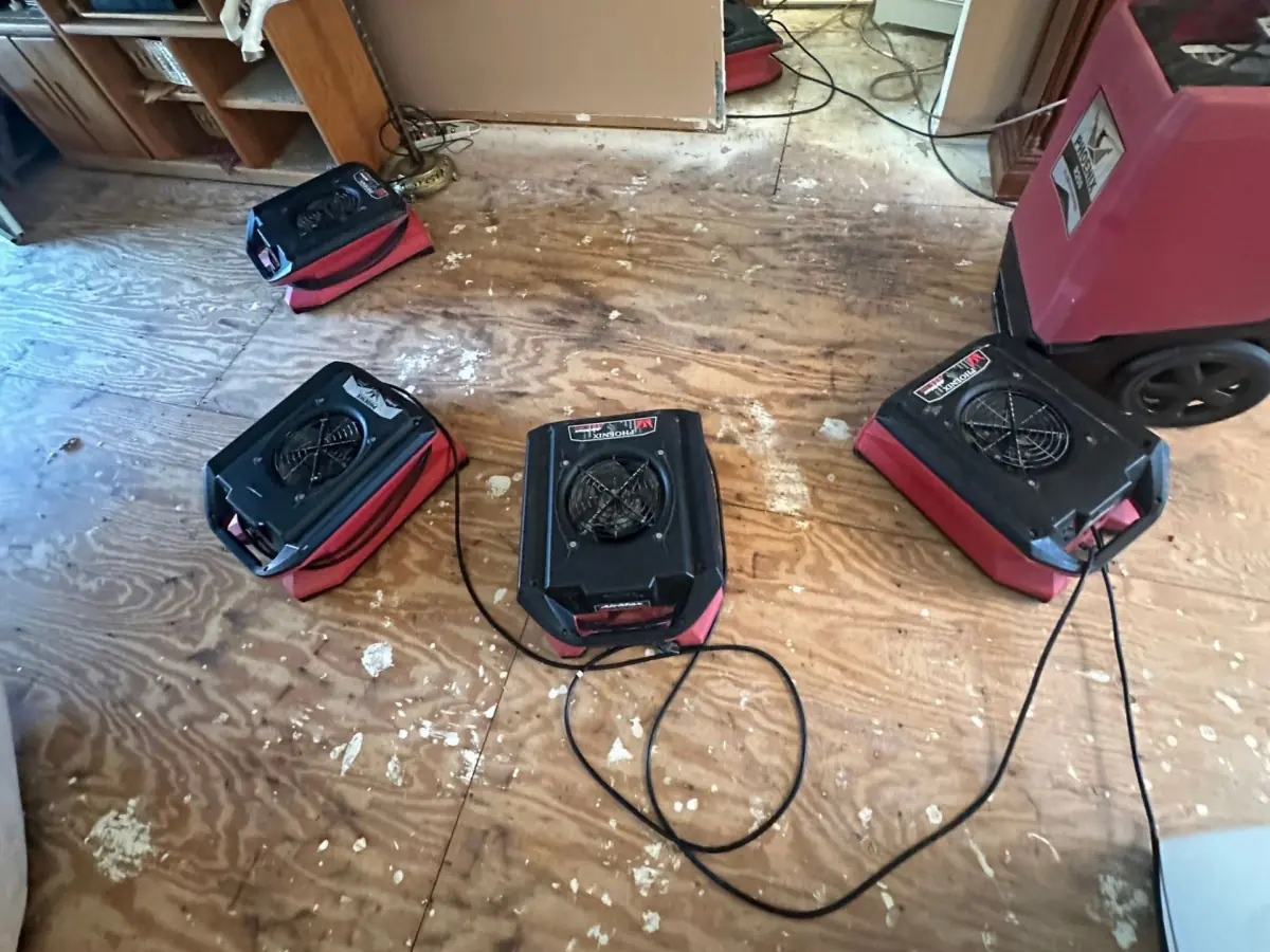Air movers drying the exposed plywood subfloor