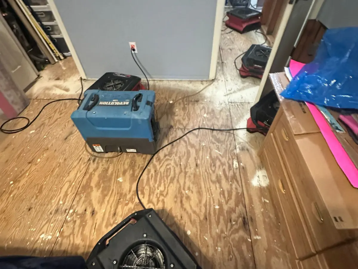 Dehumidifier and air movers drying the bedroom subfloor