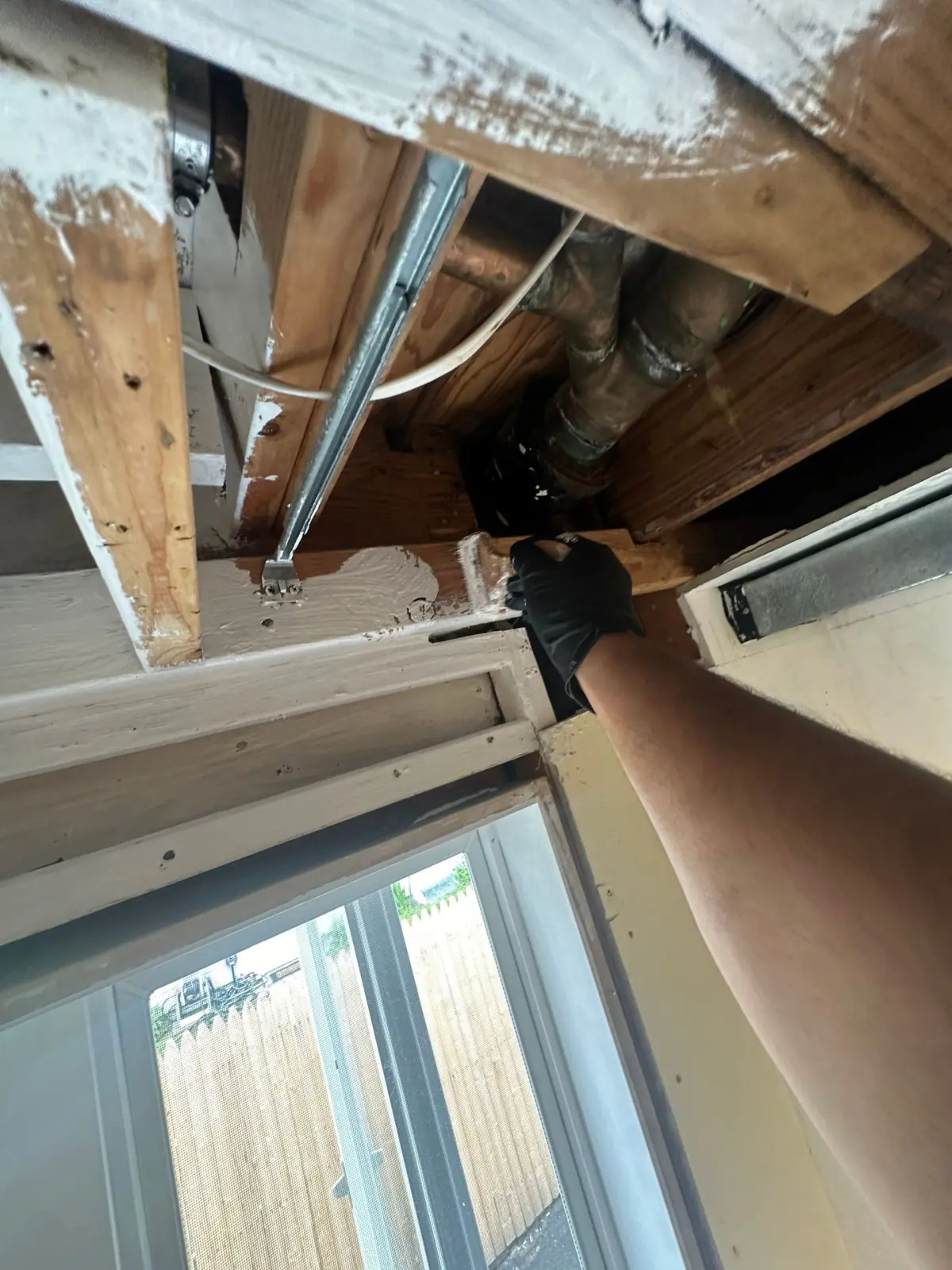 Cleaning the joists and pipes inside the opened ceiling cavity