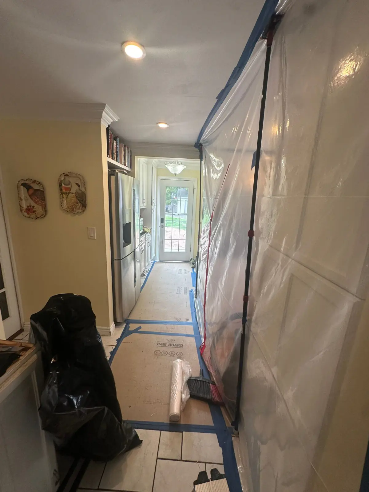 Kitchen hallway sealed with plastic containment and floor protection
