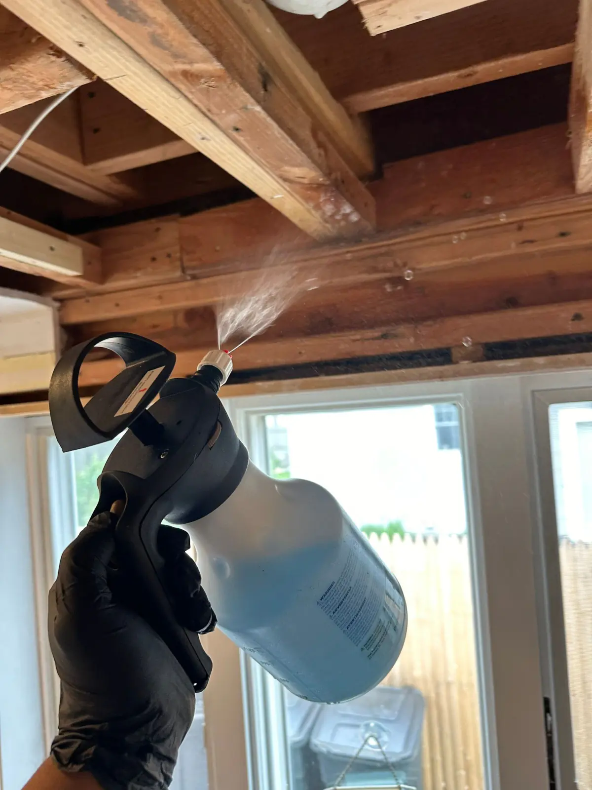 Spraying treatment onto exposed ceiling joists