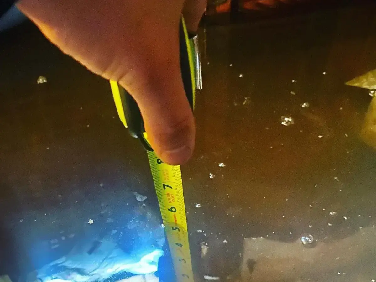 Tape measure showing the floodwater depth in a flooded basement