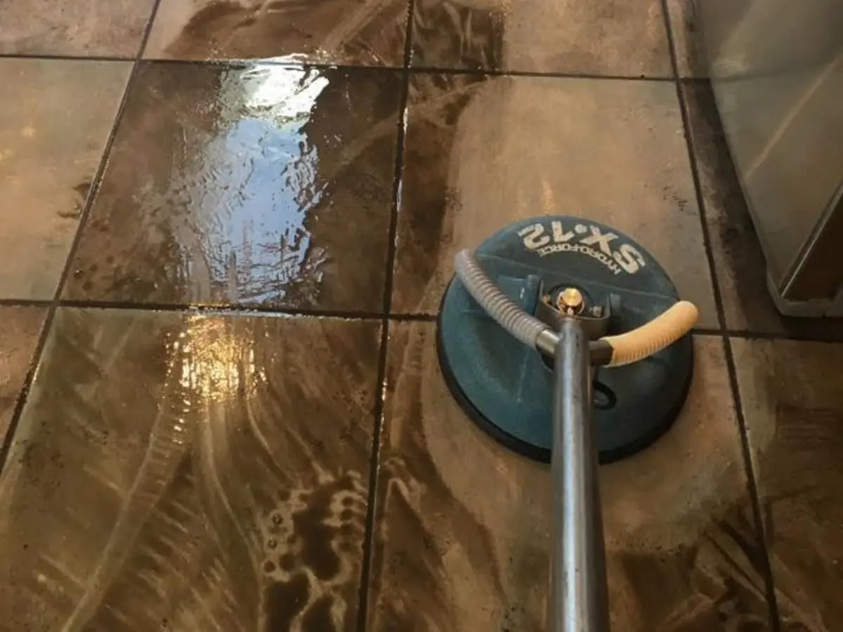 Rotary cleaning tool lifting grime from a tile floor