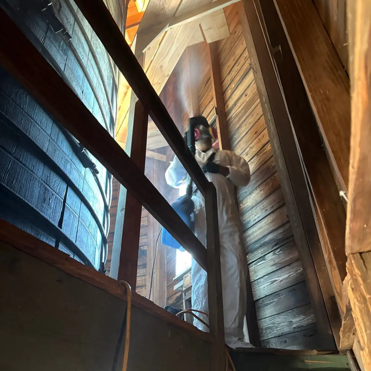 Technician disinfecting wall boards from the windmill's upper walkway