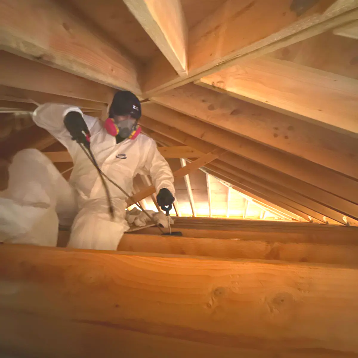 Technician in a respirator cleaning between the windmill's roof rafters
