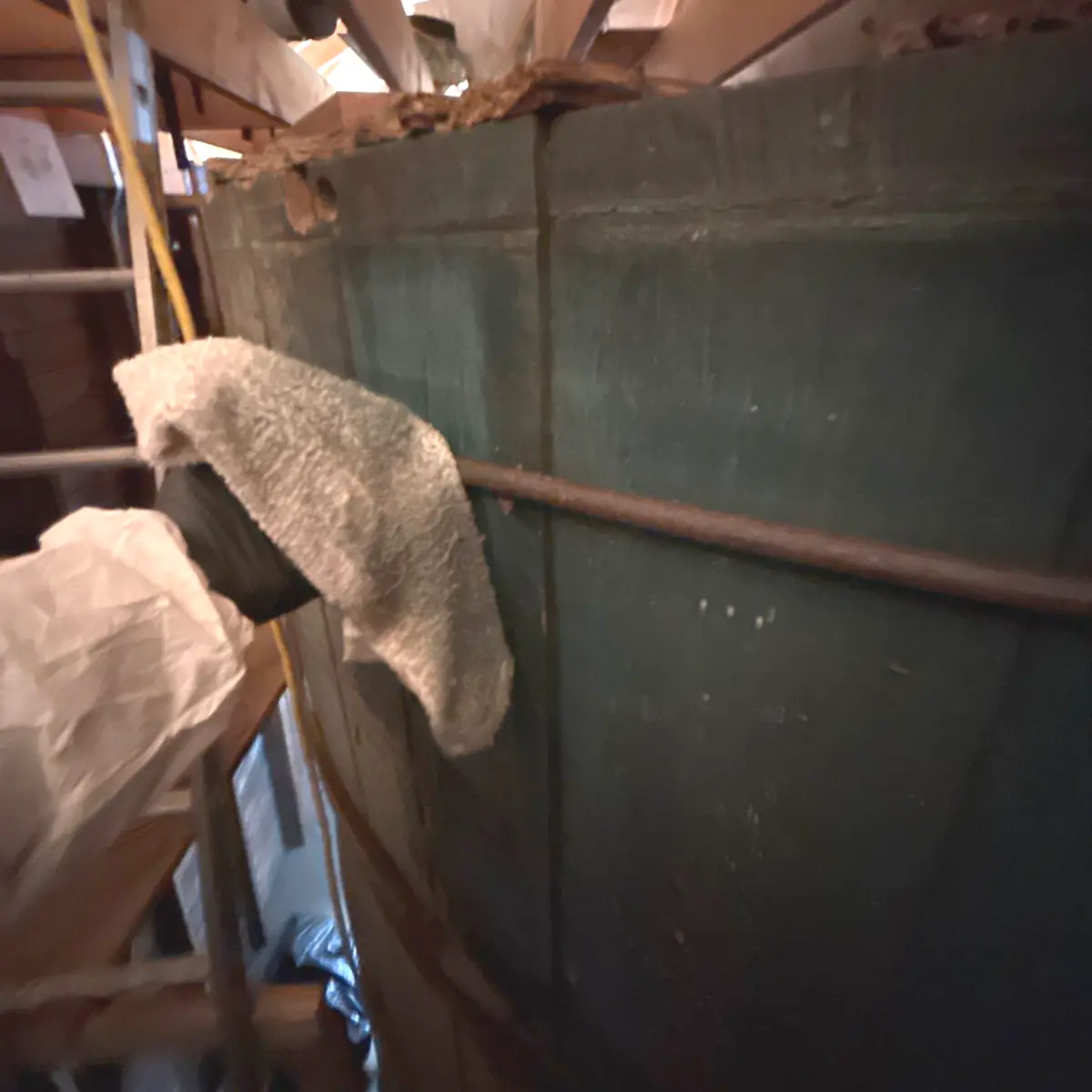 Hand-cleaning the top edge of the windmill's curved green wall