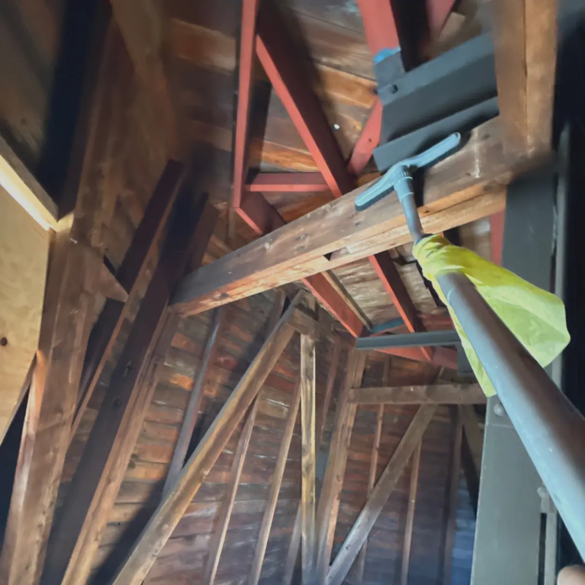 Extension pole cleaning the windmill's upper framing
