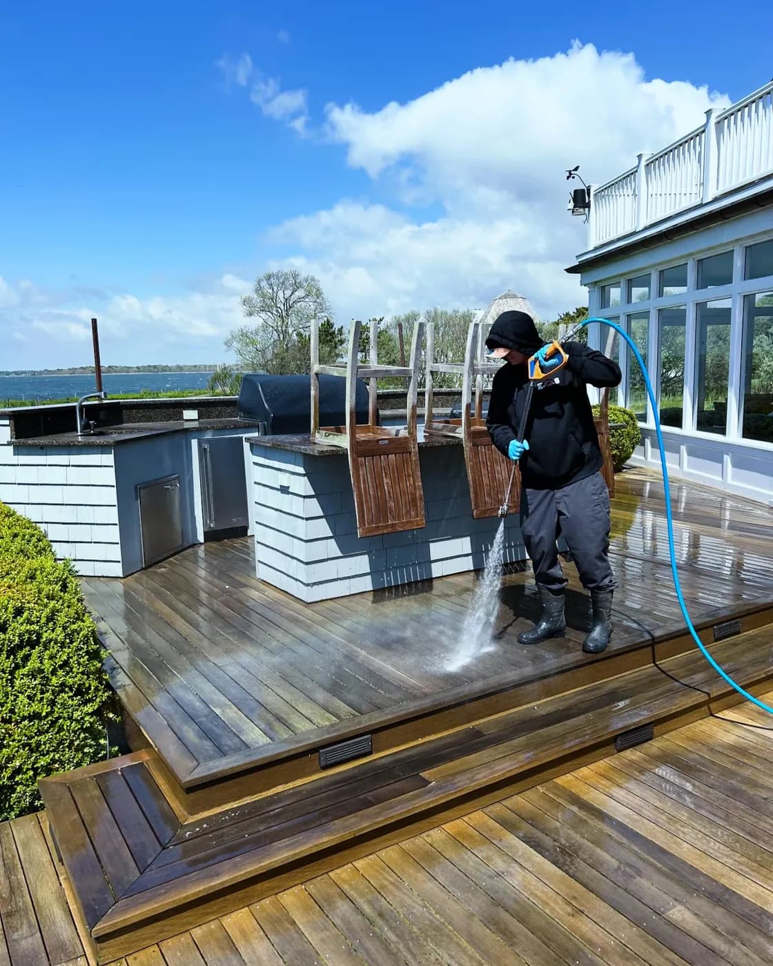 K.O.S. technician pressure-washing a waterfront wood deck