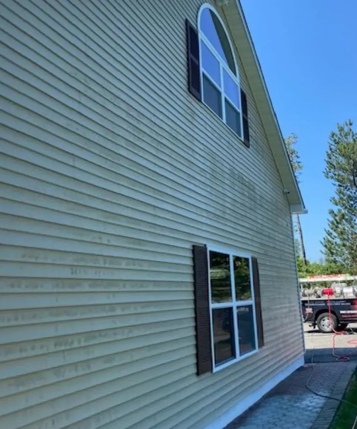 Vinyl siding streaked green with algae before soft washing